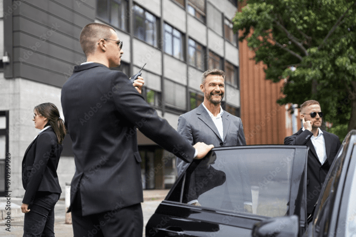 Two men in suits and ties standing next to a car.