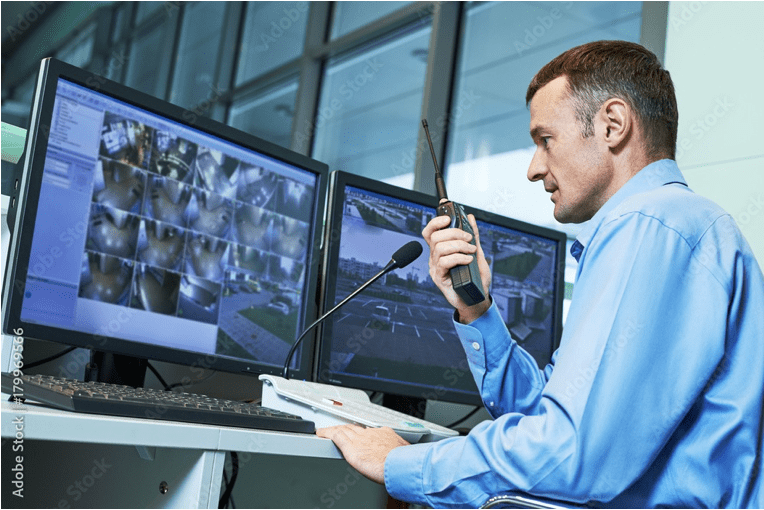 A man sitting at a desk with two monitors.