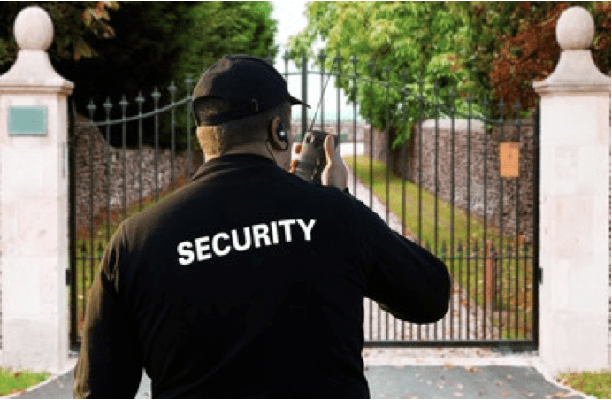 A security guard taking pictures of the gate.