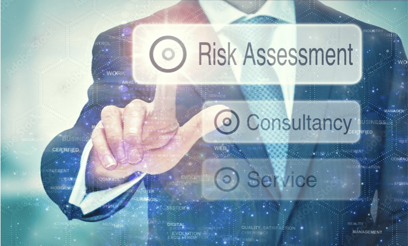 A man in business attire pointing to the words " risk assessment ".