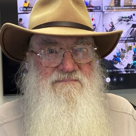 A man with long white beard wearing a hat.